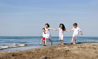 happy child group playing  on beach photo