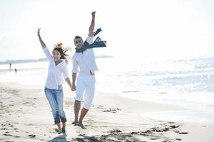 feliz pareja joven divertirse en la hermosa playa foto