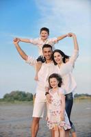 familia joven feliz divertirse en la playa foto