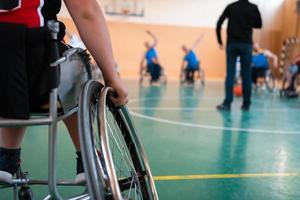 the selector of the basketball team with a disability stands in front of the players and shows them the stretching exercises before the start of training photo