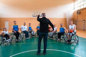 selector explico nuevas tácticas a jugadores de baloncesto en sillas de ruedas, los jugadores se sientan en sillas de ruedas escuchando al selector foto