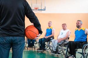 selector I explain new tactics to basketball players in wheelchairs, players sit in wheelchairs listening to the selector photo