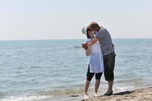 feliz pareja joven divertirse en la playa foto