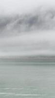 le brouillard flotte parmi la ligne de rivage de la forêt de montagne vue du bateau video