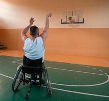 un camarógrafo con equipo profesional graba un partido de la selección nacional en silla de ruedas jugando un partido en la arena foto