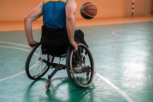 Close up photo of wheelchairs and handicapped war veterans playing basketball on the court