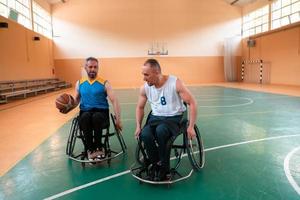 veteranos de guerra discapacitados en acción mientras juegan baloncesto en una cancha de baloncesto con equipo deportivo profesional para discapacitados foto