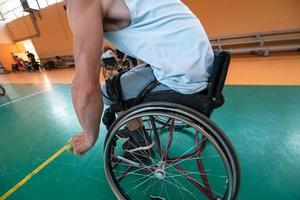 Disabled War veterans mixed race and age basketball teams in wheelchairs playing a training match in a sports gym hall. Handicapped people rehabilitation and inclusion concept photo