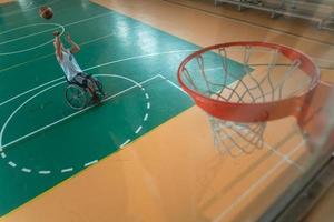 tow view photo of a war veteran playing basketball in a modern sports arena. The concept of sport for people with disabilities