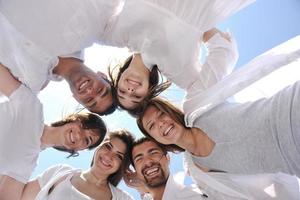 Group of happy young people in circle at beach photo