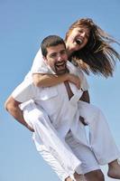 happy young couple have fun on beach photo