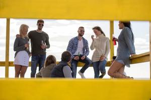 grupo de amigos divirtiéndose el día de otoño en la playa foto