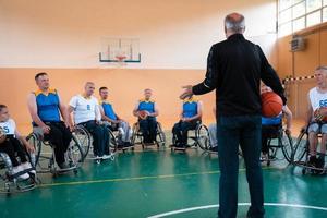 selector I explain new tactics to basketball players in wheelchairs, players sit in wheelchairs listening to the selector photo