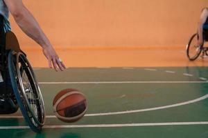 Close up photo of wheelchairs and handicapped war veterans playing basketball on the court