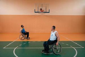 veteranos de guerra discapacitados en acción mientras juegan baloncesto en una cancha de baloncesto con equipo deportivo profesional para discapacitados foto