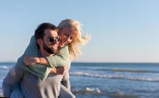 pareja divirtiéndose en la playa durante el otoño foto