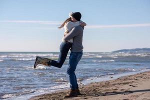 amorosa pareja joven en una playa en el día soleado de otoño foto