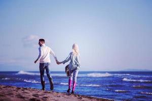 Loving young couple on a beach at autumn sunny day photo