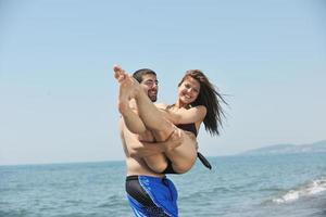 happy young couple have fun on beach photo