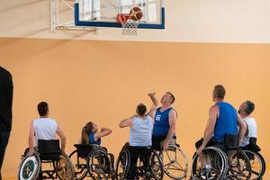 veteranos de guerra discapacitados en acción mientras juegan baloncesto en una cancha de baloncesto con equipo deportivo profesional para discapacitados foto