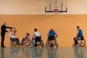 Disabled War veterans mixed race opposing basketball teams in wheelchairs photographed in action while playing an important match in a modern hall. photo