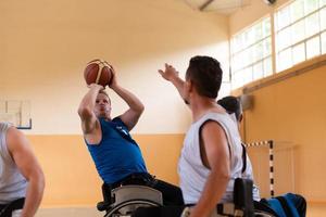 handicapped war veterans in wheelchairs with professional equipment play basketball match in the hall.the concept of sports with disabilities photo