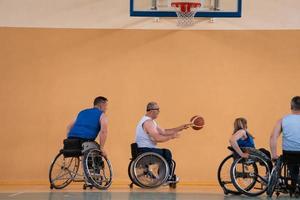 Disabled War veterans mixed race opposing basketball teams in wheelchairs photographed in action while playing an important match in a modern hall. photo