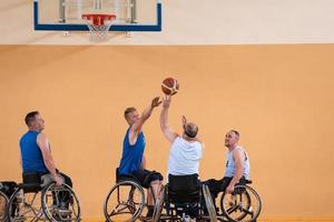 Disabled War veterans mixed race opposing basketball teams in wheelchairs photographed in action while playing an important match in a modern hall. photo