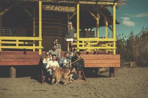 grupo de amigos divirtiéndose el día de otoño en la playa foto