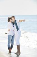 feliz pareja joven divertirse en la hermosa playa foto