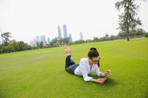 hermosa mujer joven con tableta en el parque foto