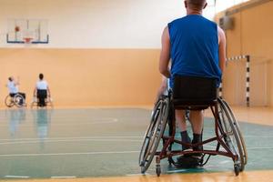 Close up photo of wheelchairs and handicapped war veterans playing basketball on the court