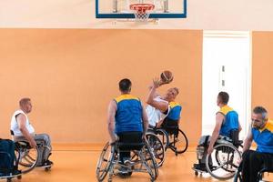 Disabled War veterans mixed race and age basketball teams in wheelchairs playing a training match in a sports gym hall. Handicapped people rehabilitation and inclusion concept photo