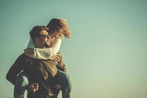 pareja divirtiéndose en la playa durante el otoño foto