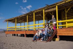 grupo de amigos divirtiéndose el día de otoño en la playa foto