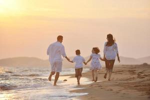 familia joven feliz divertirse en la playa foto