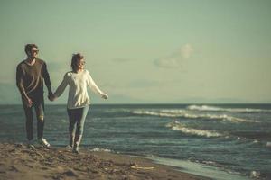 Loving young couple on a beach at autumn sunny day photo