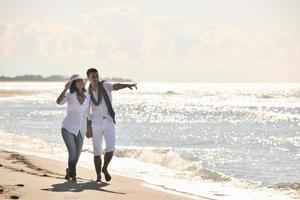 feliz pareja joven divertirse en la hermosa playa foto