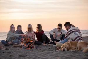 Friends having fun at beach on autumn day photo