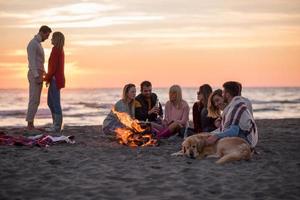 Couple enjoying with friends at sunset on the beach photo