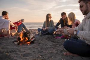 Friends having fun at beach on autumn day photo