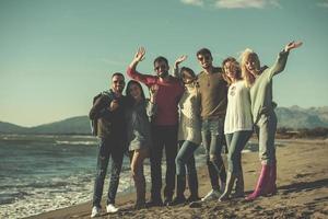 portrait of friends having fun on beach during autumn day photo