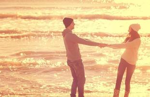 amorosa pareja joven en una playa en el día soleado de otoño foto