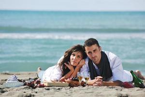 young couple enjoying  picnic on the beach photo