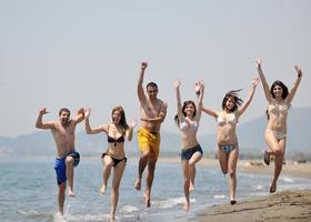 grupo de jóvenes felices divertirse en la playa foto