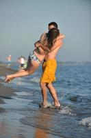 feliz pareja joven divertirse en la playa foto