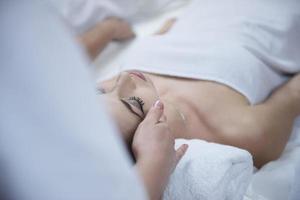 woman getting face and head  massage in spa salon photo