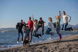 young friends jumping together at autumn beach photo