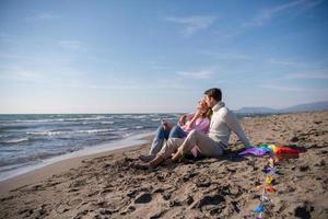 pareja joven disfrutando del tiempo juntos en la playa foto