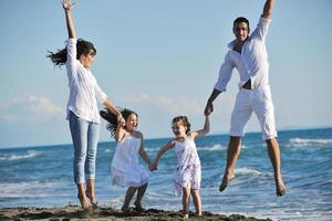 familia joven feliz divertirse en la playa foto